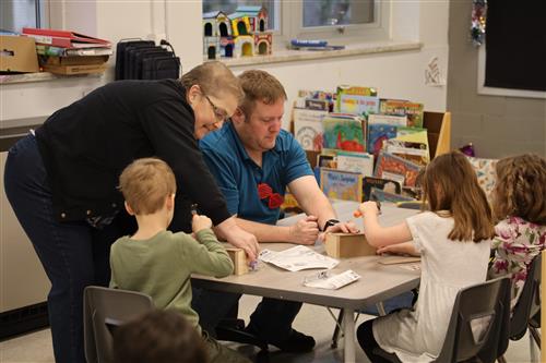 Mr. Buehner works with students on Kids Workshop
